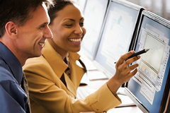 CMOs photo of 2 people looking at information on a computer screen